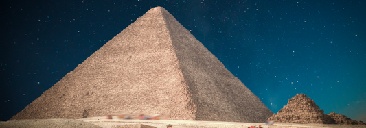 he Great Pyramid of Khufu under a twilight sky, viewed from ground level.
