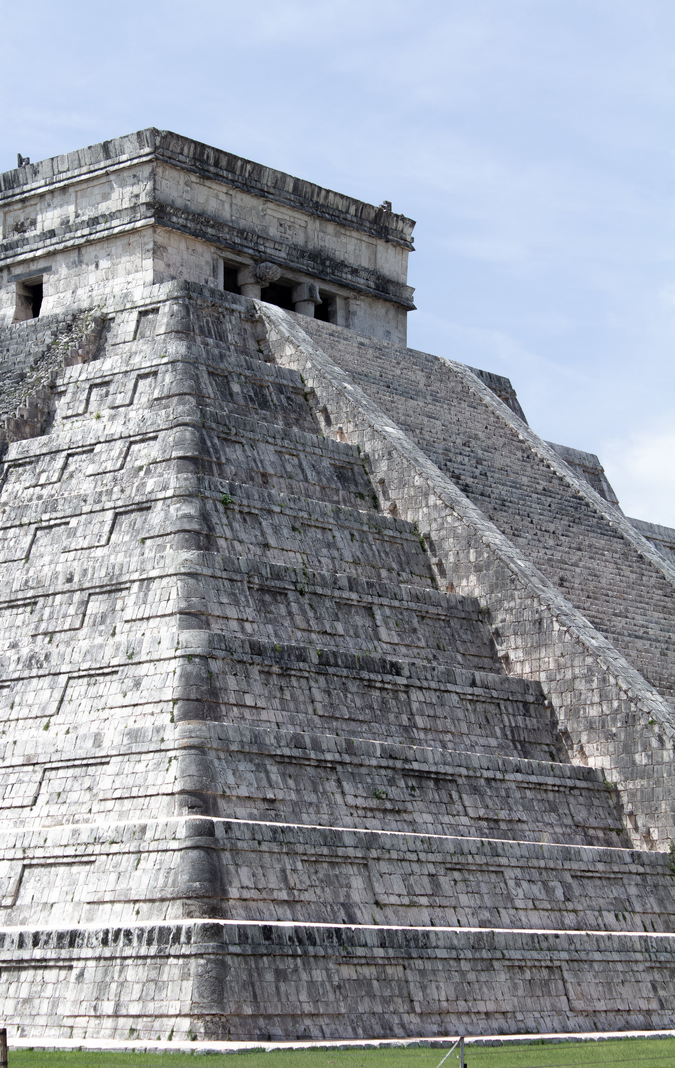 Ancient stone pyramid under a clear blue sky on a sunny day.
