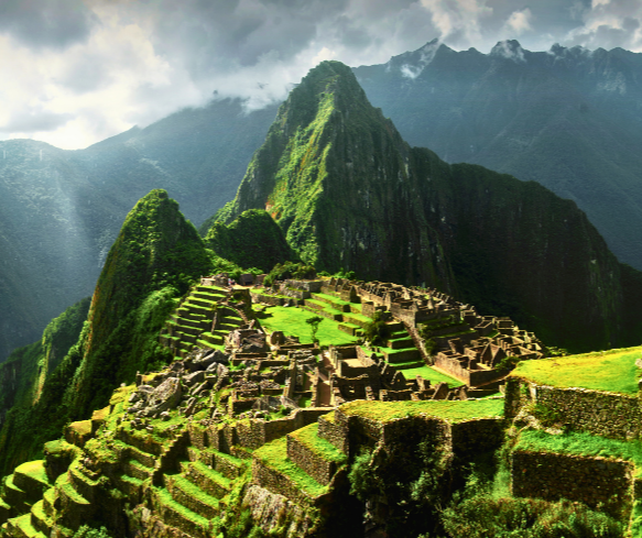 Aerial view of the Incan citadel Machu Picchu in Peru, nestled among green mountains with stone terraces and temples.
